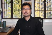 Professor Bahrawi smiling slightly while staring directly onto the camera inside his office.