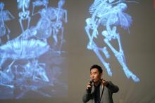 Prof. Ungsan Kim delivers a lecture against a backdrop of slides showing x-rays of skeletons
