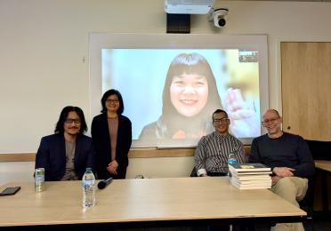 Tony Bui, Bich-Ngoc Turner, Quan Manh Ha, and Christoph Giebel sit for a photo with Kieu Bich Hau joining via Zoom