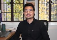 Professor Bahrawi smiling slightly while staring directly onto the camera inside his office.