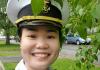 An image of Tran Huynh Bao Ho, smiling and in uniform, against a backdrop of green leaves. 