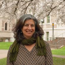 An image of Prof. Davinder Bhowmik in the UW Quad with cherry trees blooming in the background.